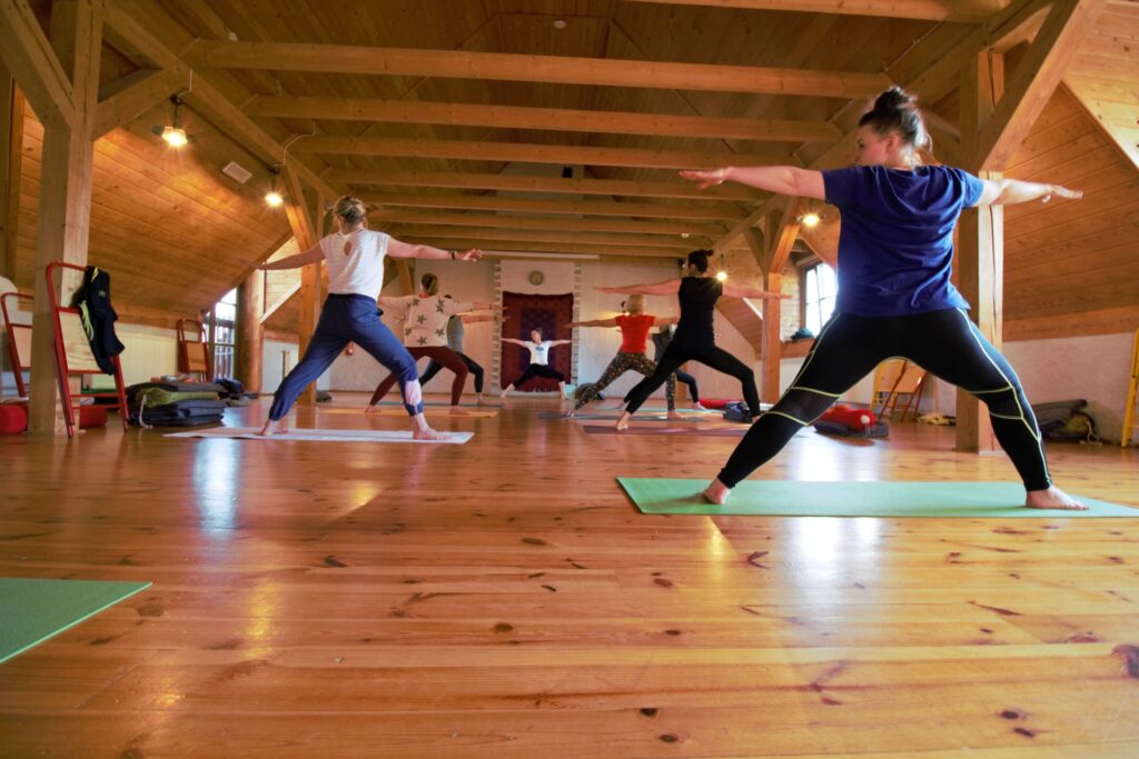 grupa ćwicząca jogę na dużej sali Joga i warsztaty rozwojowe wege kuchnia